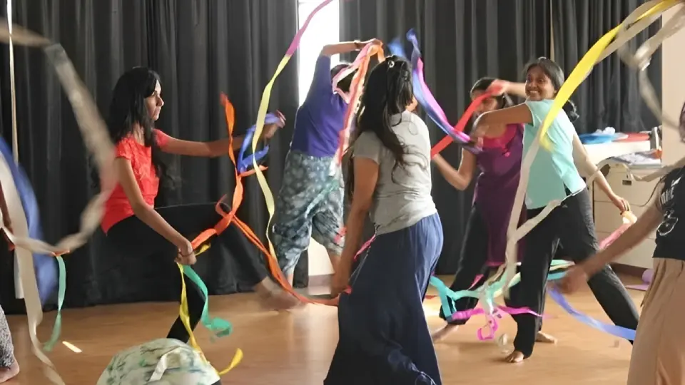 Dancers performing with colorful ribbons on stage.