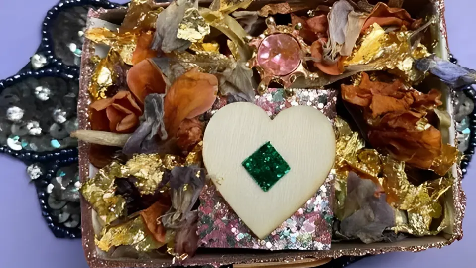 A heart-shaped white object with a green square in the center among colorful materials.