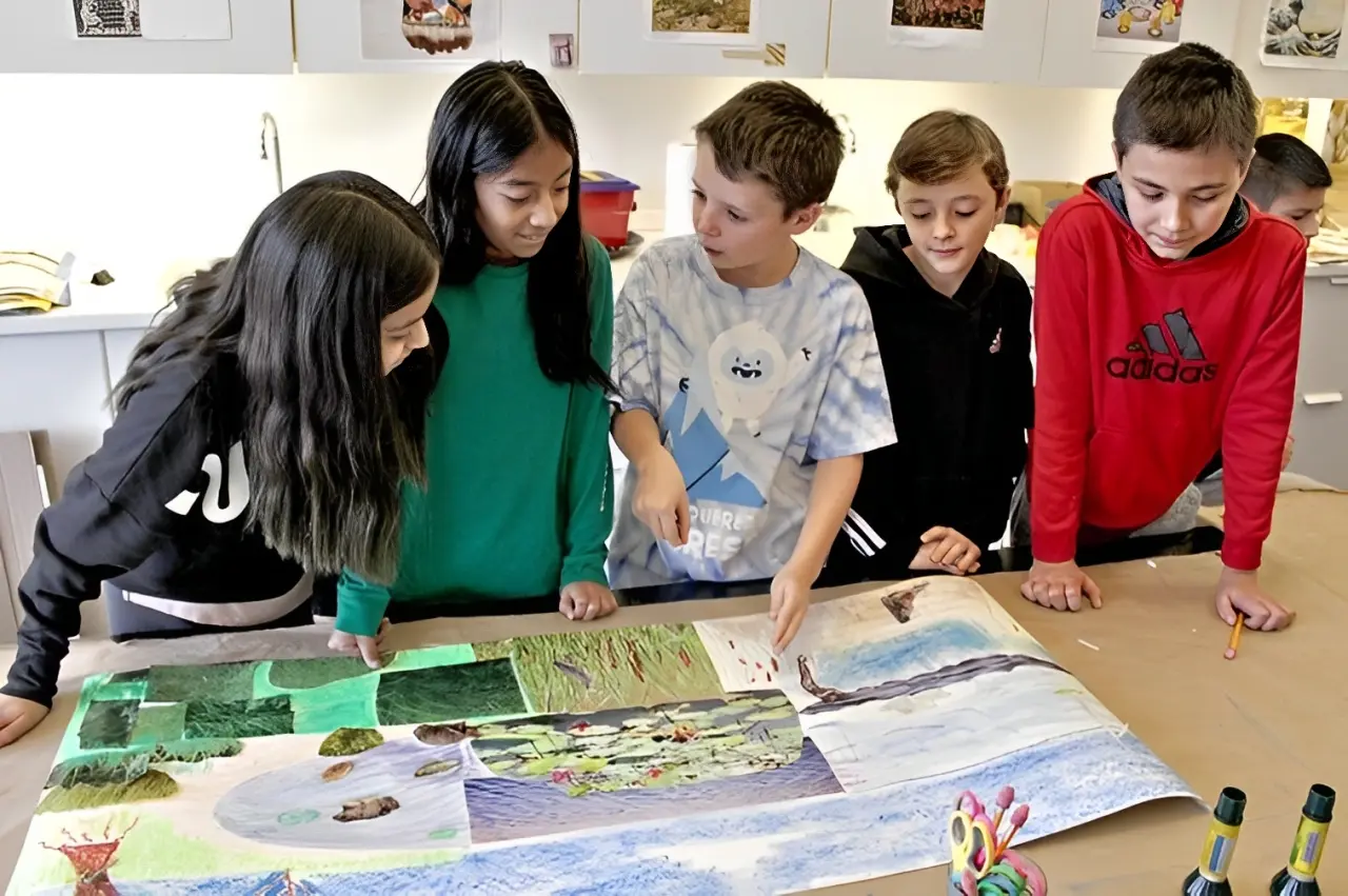 Children engaged in a group art project at a table.