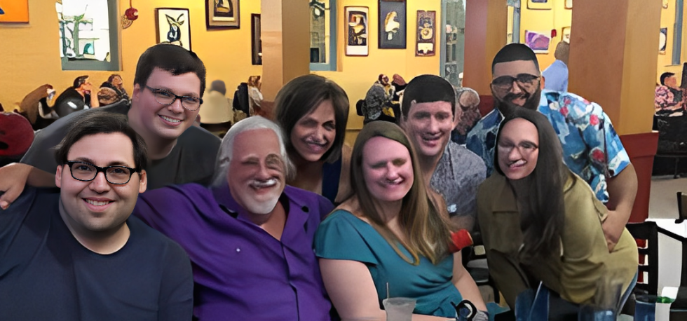 A group of five people smiling indoors.