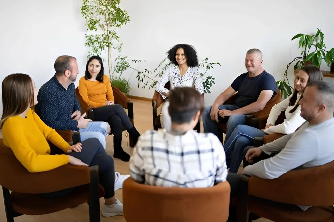 A diverse group engaged in a group therapy session.