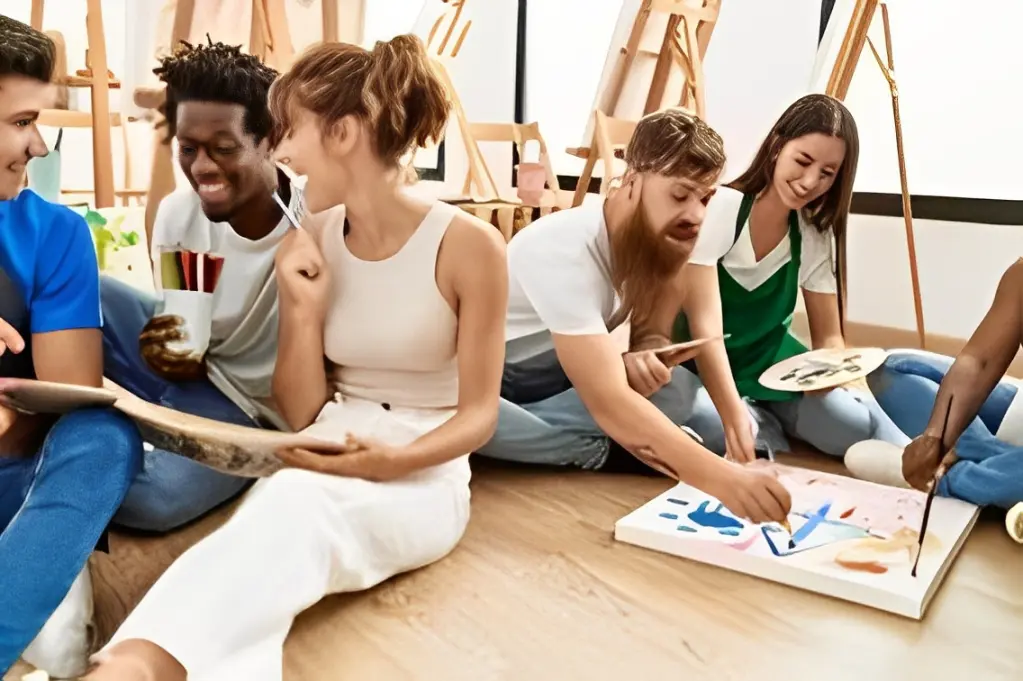 A diverse group painting together in a bright studio.