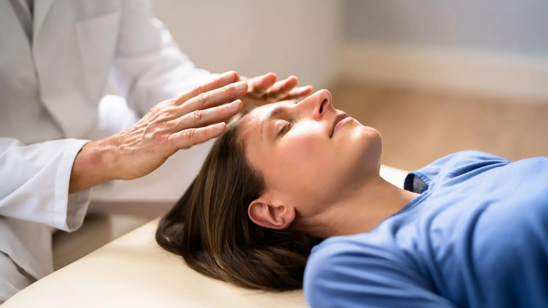 14.GettyImages-1394635955 A person receiving a gentle head massage while lying down.
