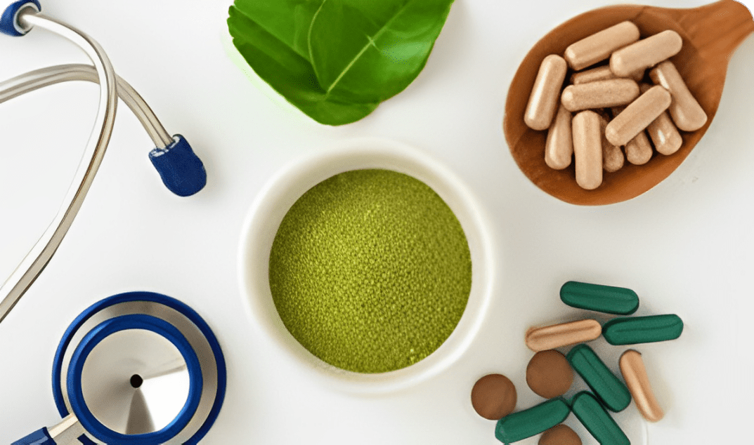 A bowl of green powder surrounded by capsules and tablets.