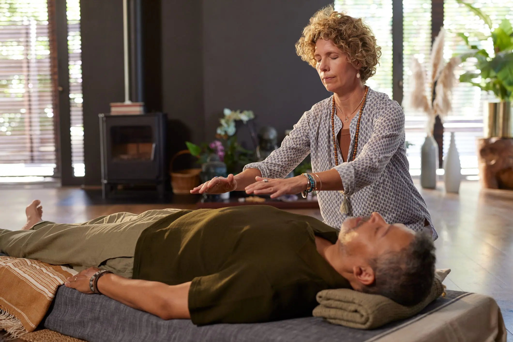 Woman performing reiki energy healing on man